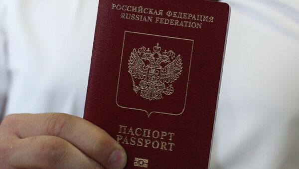 Сотрудник паспортно-визового центра демонстрирует заграничный паспорт - Sputnik Узбекистан