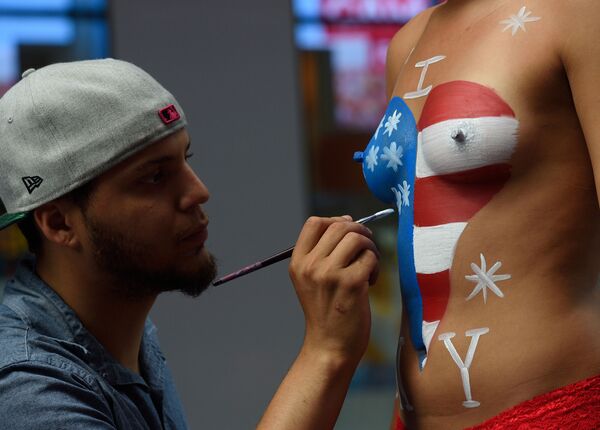 Художник рисует американский флаг на теле женщины для фотосессии с туристами на Таймс-свкер в Нью-Йорке - Sputnik Узбекистан