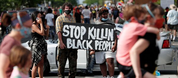Протестующие с плакатом и в защитных масках в Миннеаполисе, США Протестующие с плакатом и в защитных масках в Миннеаполисе, США - Sputnik Ўзбекистон