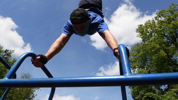 Молодой человек во время выполнения физических упражнений в парке ДК Химиков в Казани - Sputnik Узбекистан