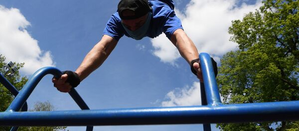 Молодой человек во время выполнения физических упражнений в парке ДК Химиков в Казани - Sputnik Узбекистан