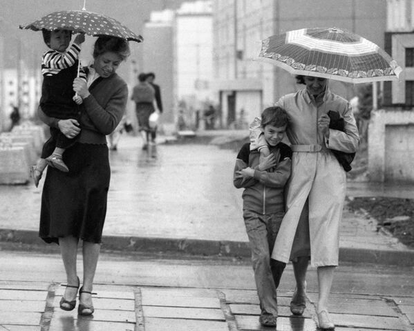 Прохожие идут по улице, прячась от дождя под зонтом. - Sputnik Узбекистан