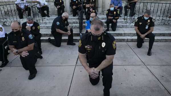 Полицейские стоят на коленях во время митинга в Корал-Гейблс, штат Флорида, в связи со смертью Джорджа Флойда - Sputnik Ўзбекистон