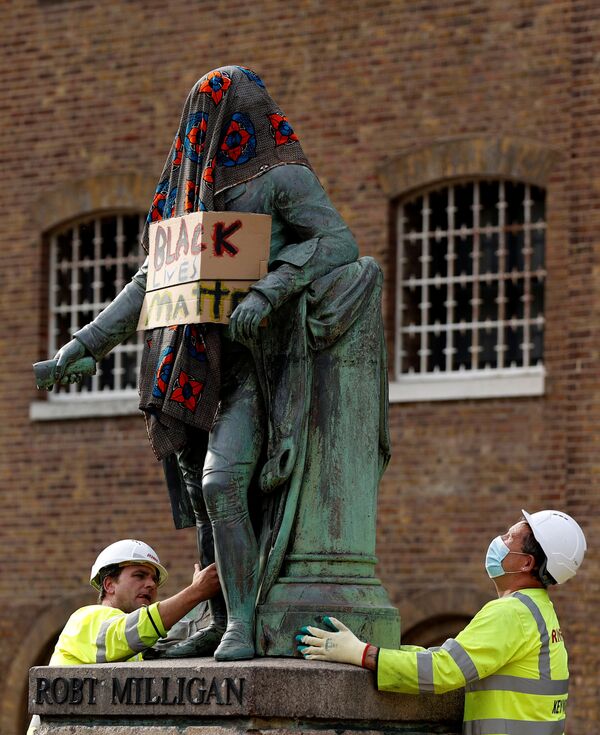  Рабочие убирают статую Роберта Миллигана, накрытую одеялом и с надписью Black Lives Matter, Лондон, Великобритания. - Sputnik Узбекистан