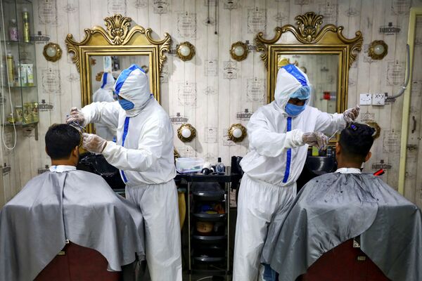Барберы в защитных костюмах в одном из парикмахерских салонов Дакки, Бангладеш. - Sputnik Узбекистан
