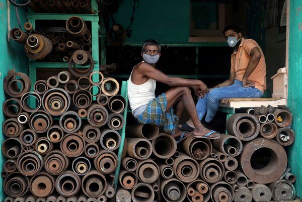 Рабочие в защитных масках в магазине, торгующем железными трубами на оптовом рынке в Калькутте, Индия. - Sputnik Узбекистан