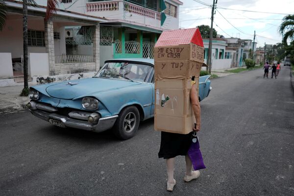 Женщина в картонной конструкции для защиты от коронавируса на улице в Гаване, Куба. - Sputnik Узбекистан