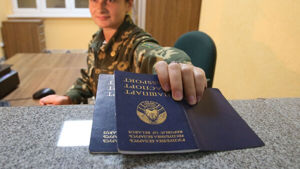 Пограничник проверяет паспорта на пограничном переходе между Беларусью и Польшей Переров - Sputnik Узбекистан