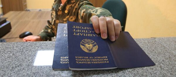 Пограничник проверяет паспорта на пограничном переходе между Беларусью и Польшей Переров - Sputnik Узбекистан