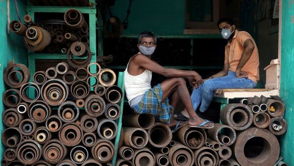 Рабочие в защитных масках в магазине, торгующем железными трубами на оптовом рынке в Калькутте, Индия - Sputnik Ўзбекистон