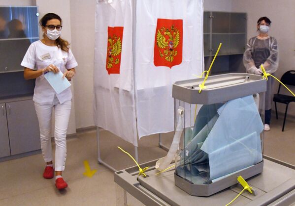 Медицинский работник принимает участие в голосовании по внесению поправок в Конституцию РФ на избирательном участке в Приморском краевом перинатальном центре во Владивостоке - Sputnik Узбекистан