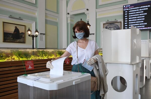Женщина голосует по одобрению внесения поправок в Конституцию РФ на избирательном участке на Курском вокзале в Москве - Sputnik Узбекистан