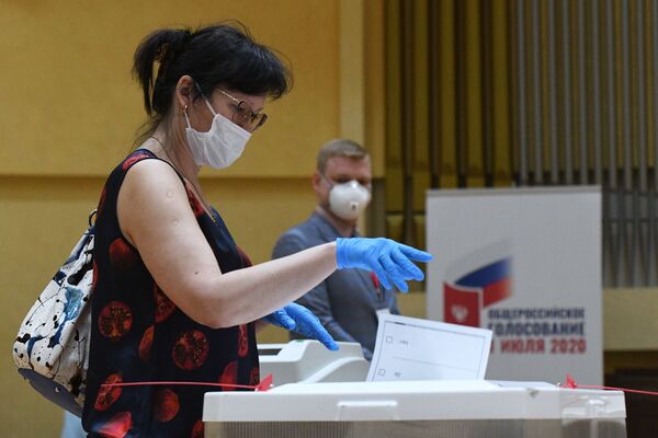 Женщина голосует по одобрению внесения поправок в Конституцию РФ на избирательном участке № 145 в Москве - Sputnik Узбекистан