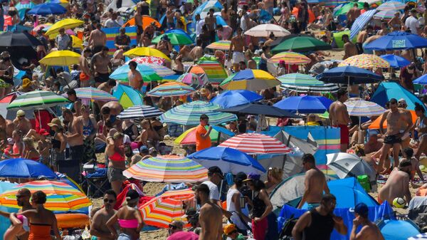 Люди наслаждаются жаркой погодой на пляже в Борнмуте, Великобритания - Sputnik Ўзбекистон