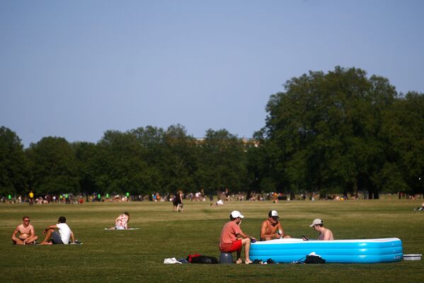 Люди отдыхают в надувном бассейне в Лондоне, Великобритания - Sputnik Узбекистан