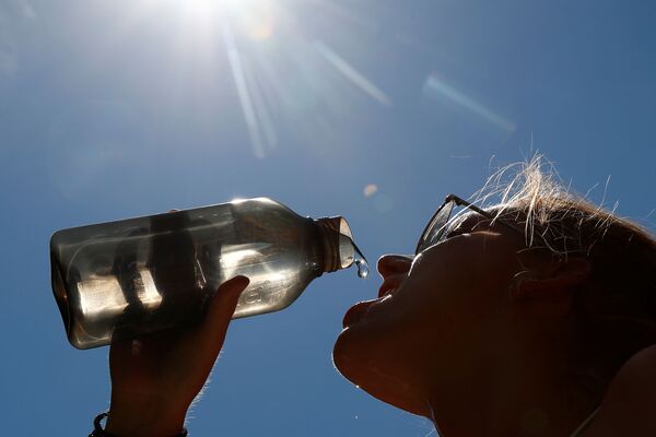 Женщина пьет воду в парке в центре Брюсселя, Бельгия - Sputnik Узбекистан