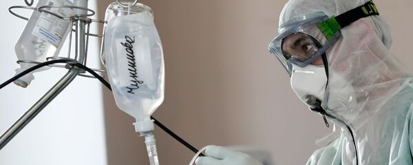 Meditsinskiy sotrudnik ustanavlivayet kapelnitsu v statsionare dlya bolnix s koronavirusnoy infeksiyey - Sputnik O‘zbekiston