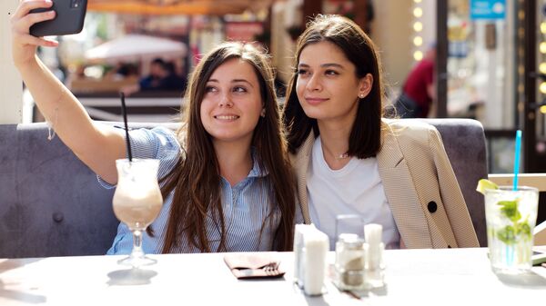 Девушки в летнем кафе на улице Старый Арбат после снятия карантина в Москве - Sputnik Ўзбекистон