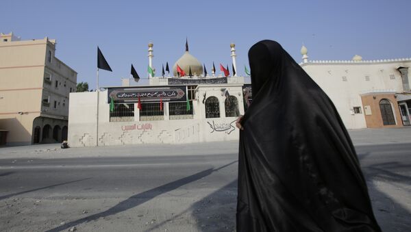 Женщина проходит мимо шиитской мусульманской мечети в Бахрейне - Sputnik Узбекистан
