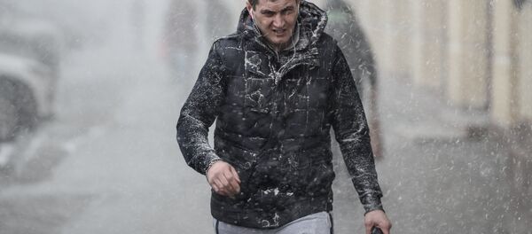 Прохожий на улице во время снегопада Прохожий на улице во время снегопада - Sputnik Узбекистан