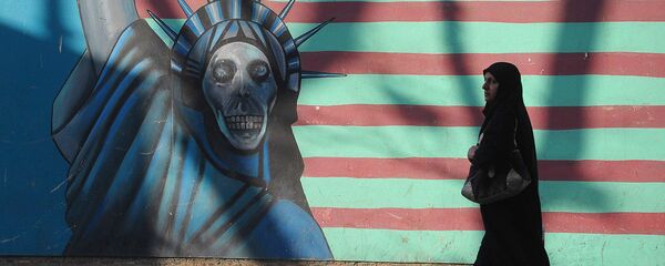 Женщина идет вдоль стены здания бывшего посольства США в Тегеране. Женщина идет вдоль стены здания бывшего посольства США в Тегеране. - Sputnik Ўзбекистон