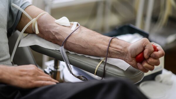 Донор во время процедуры сдачи крови на станции переливания крови - Sputnik Узбекистан