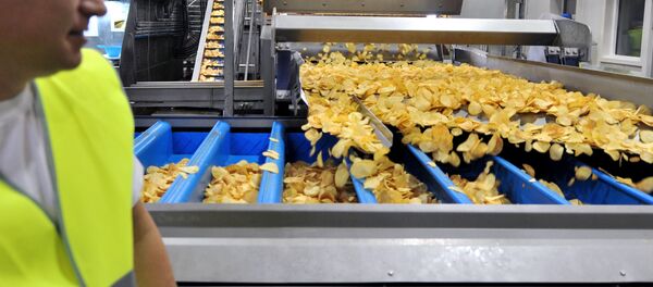 Рабочий завода следит за производством картофельных снеков. Рабочий завода следит за производством картофельных снеков. - Sputnik Узбекистан