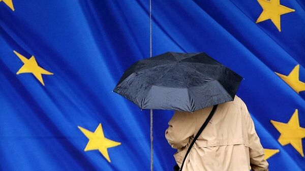 Женщина под зонтом рядом с флагом ЕС - Sputnik Узбекистан