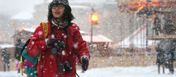 Прохожая на Красной площади во время снегопада в Москве Прохожая на Красной площади во время снегопада в Москве - Sputnik Узбекистан