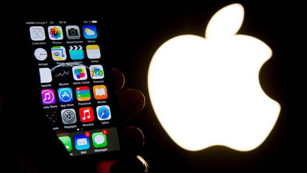 iPhone на фоне логотипа Apple. - Sputnik Узбекистан
