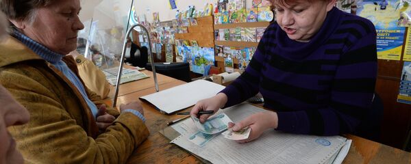 Жительница Крыма получает пенсию в почтовом отделении Жительница Крыма получает пенсию в почтовом отделении - Sputnik Узбекистан