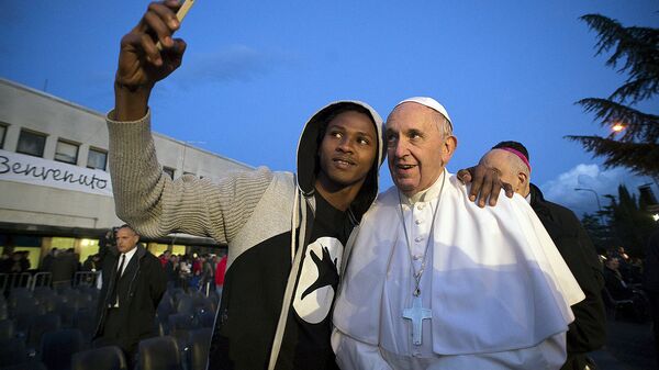 Беженец делает фотографию с Папой Римским Франциском Беженец делает фотографию с Папой Римским Франциском - Sputnik Ўзбекистон