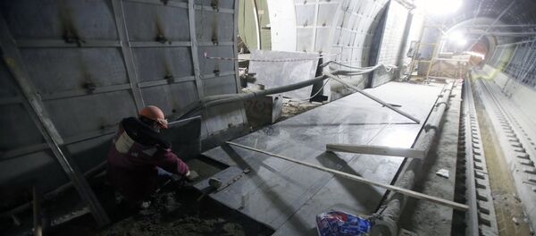 Рабочий укладывает плитку на будущей платформе Рабочий укладывает плитку на будущей платформе - Sputnik Узбекистан