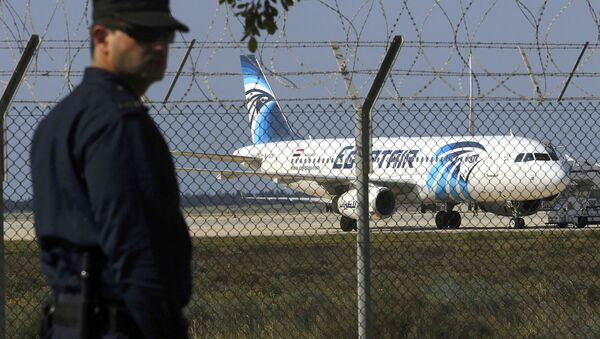 Полицейский в аэропорту Ларнаки на фоне захваченного лайнера - Sputnik Узбекистан