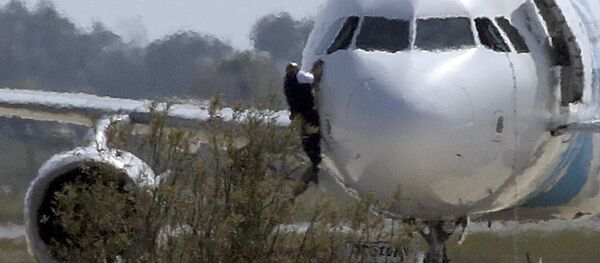 Пилот выбирается из кабины захваченного самолета Egypt Air Пилот выбирается из кабины захваченного самолета Egypt Air - Sputnik Узбекистан