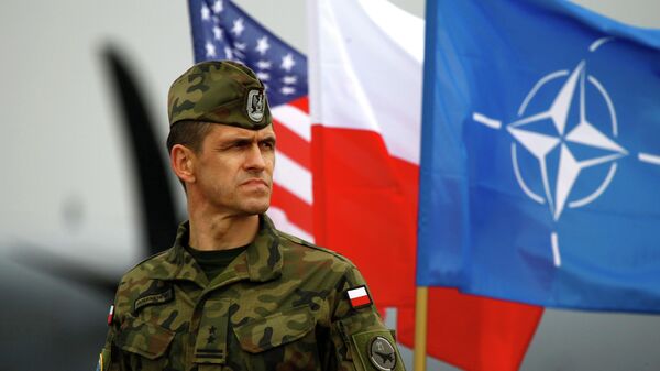 Polskiy voyennoslujaщiy na fone flaga NATO - Sputnik Oʻzbekiston