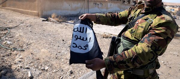 Боец сирийской армии с разорванным флагом ИГИЛ - Sputnik Узбекистан