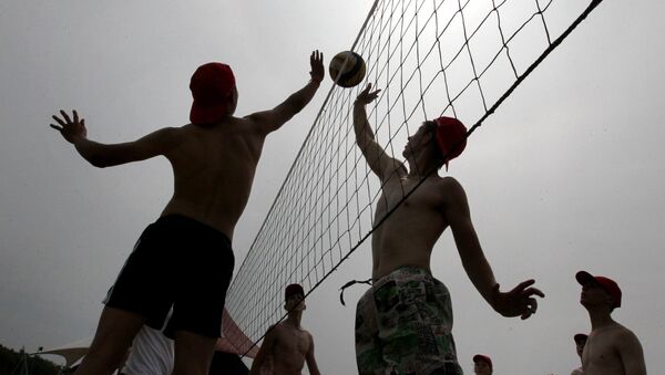 Подростки играют в волейбол на пляже в летнем лагере - Sputnik Узбекистан