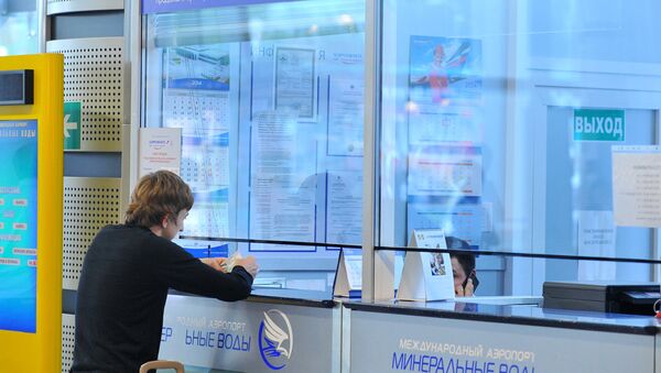Молодой человек покупает билет в кассе международного аэропорта - Sputnik Узбекистан