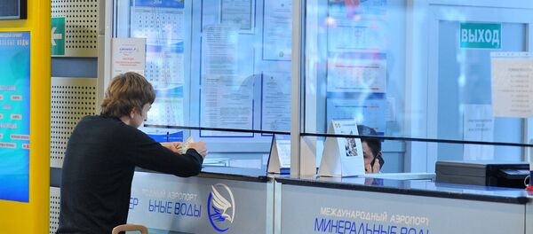 Молодой человек покупает билет в кассе международного аэропорта - Sputnik Узбекистан