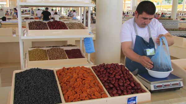 Продавец у прилавка с сухофруктами на Алайском рынке в Ташкенте - Sputnik Узбекистан
