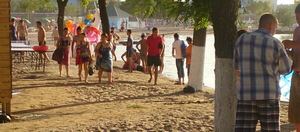 Люди оказывают помощь пострадавшему на пляже озера Бахт Люди оказывают помощь пострадавшему на пляже озера Бахт - Sputnik Узбекистан