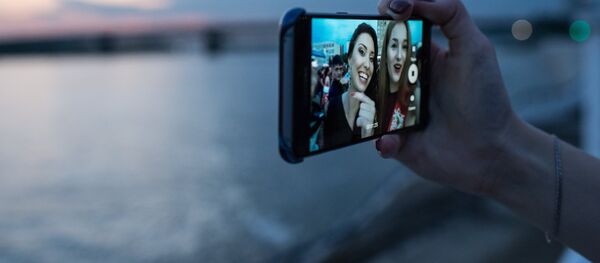 Девушки фотографируются на мобильный телефон Девушки фотографируются на мобильный телефон - Sputnik Ўзбекистон