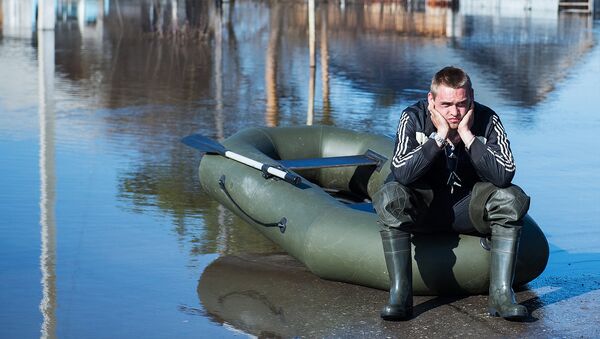 Местный житель рядом с жилыми домами, затопленными в результате паводка - Sputnik Узбекистан