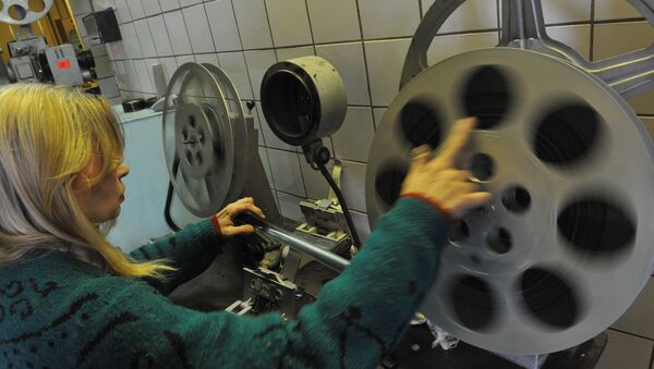Сотрудница кинотеатра заправляет бобину в кинопроектор - Sputnik Узбекистан