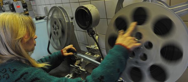 Сотрудница кинотеатра заправляет бобину в кинопроектор - Sputnik Узбекистан