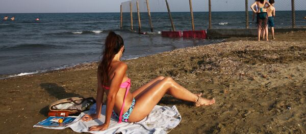 Люди с пляжа наблюдают за посадкой самолета British Airways в международном аэропорту Ларнаки - Sputnik Узбекистан