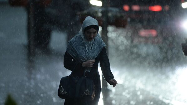 Девушка идет по улице во время сильного дождя - Sputnik Узбекистан