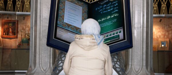 Посетительница у электронного Корана на открытии выставки Серебряный Коран в музее исламской культуры в казанской мечете Кул-Шариф. Архивное фото Посетительница у электронного Корана на открытии выставки Серебряный Коран в музее исламской культуры в казанской мечете Кул-Шариф. Архивное фото - Sputnik Узбекистан