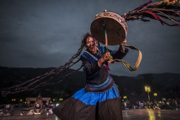Шаман одетый в традиционный костюм Йи на фестивале в Сичан. Провинция Китая Сычуань - Sputnik Узбекистан
